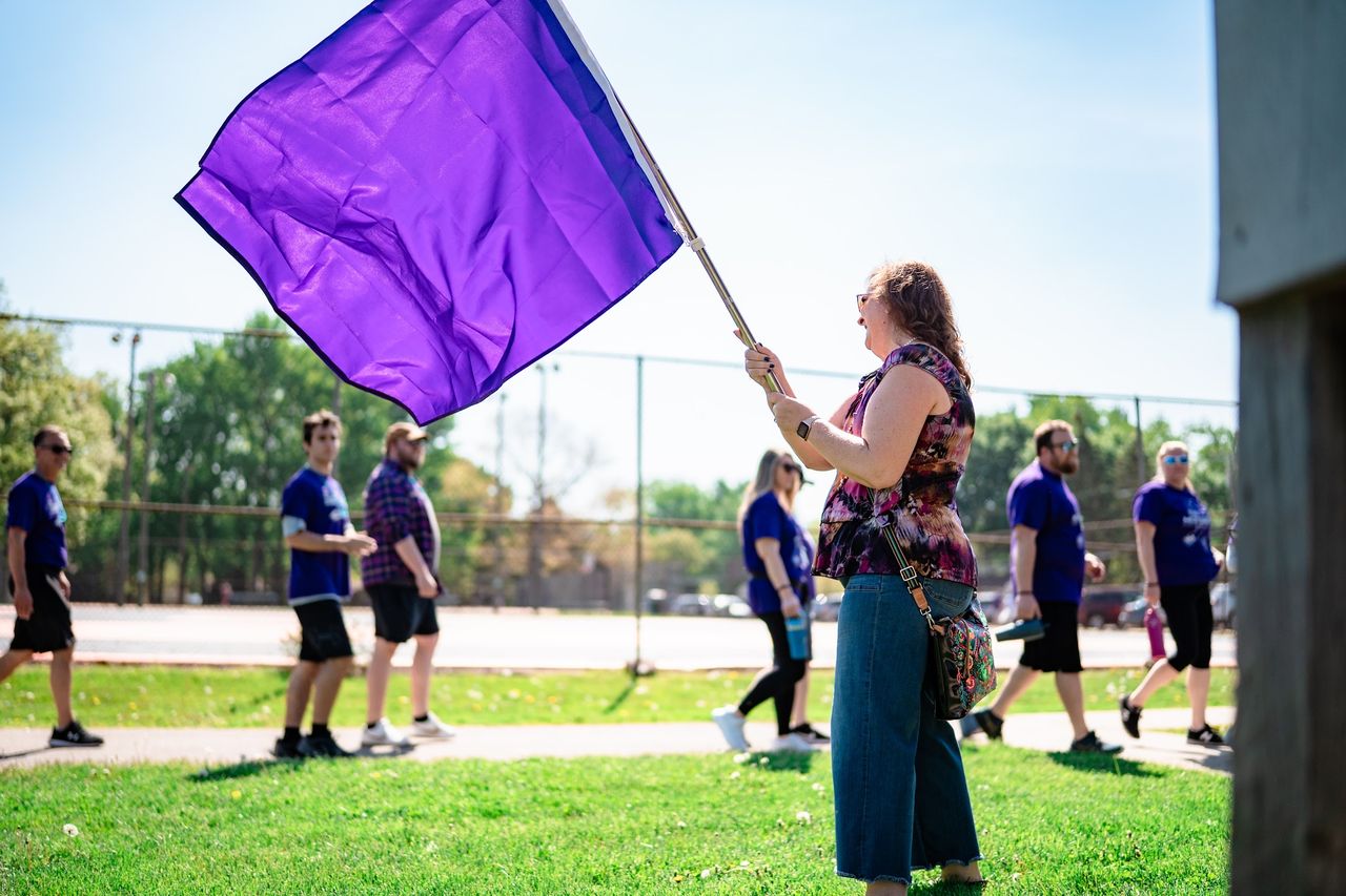 A walker waving a purple flag